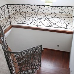 A curved hand wrought iron railing