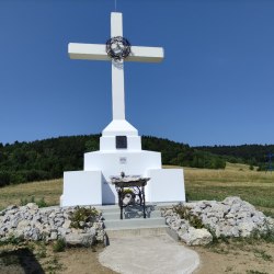 Kríž nad dedinou s ručne kovanými doplnkami
