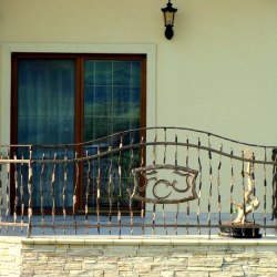 Balkónové kované zábradlie s logom pri rodinnom dome