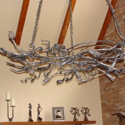 Kovaný luster visiaci na reťazi ručne vytvorený ako korene stromu - osvetlenie chalupy - interiérové luxusné svietidlo